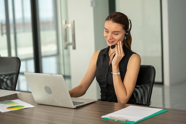 Donna di affari che utilizza la conferenza del computer portatile con il cliente