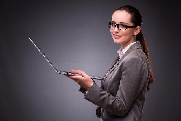 Donna di affari con il computer portatile nel concetto di affari