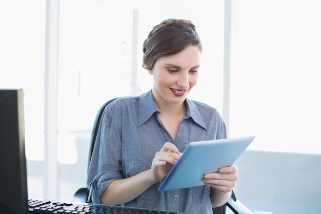 Donna di affari contenta che lavora con il suo tablet