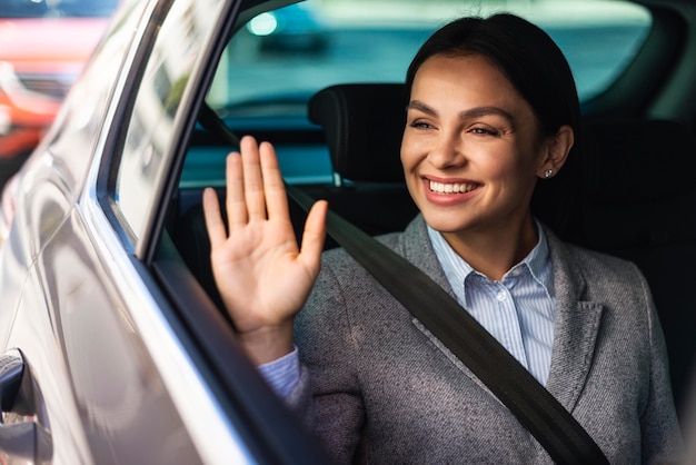 Donna di affari di smiley che fluttua dall'auto