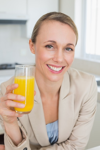 Donna di affari felice che mangia succo d&#39;arancia prima del lavoro di mattina