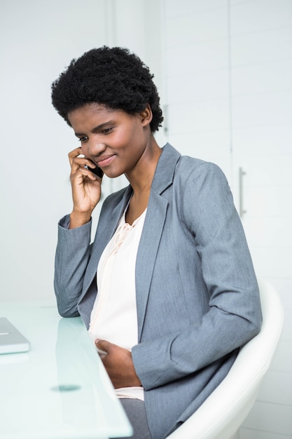 Donna di affari incinta sul telefono nell&#39;ufficio