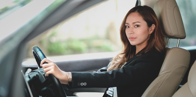 Donna di affari professionale che osserva mentre guidando l'automobile