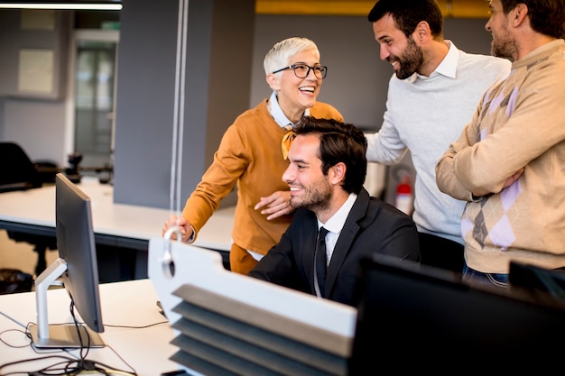 Donna di affari senior che lavora insieme ai giovani uomini d'affari in ufficio