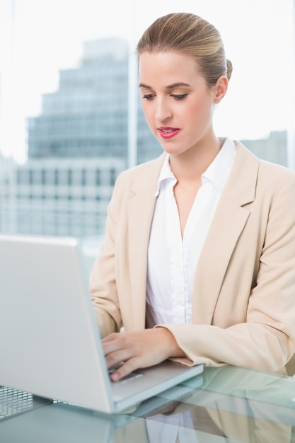 Donna di affari seria che lavora al suo computer portatile