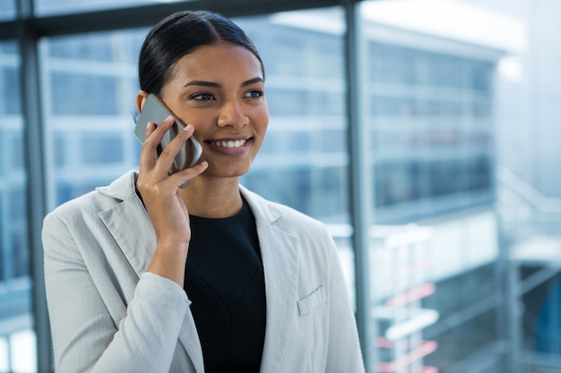 Donna di affari sorridente che parla sul telefono cellulare