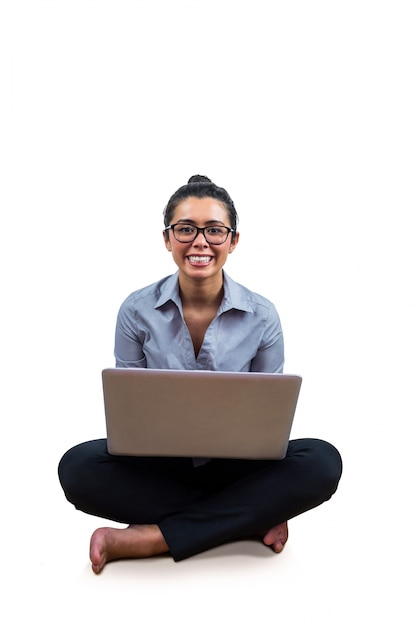 Donna di affari sorridente che per mezzo del suo computer portatile