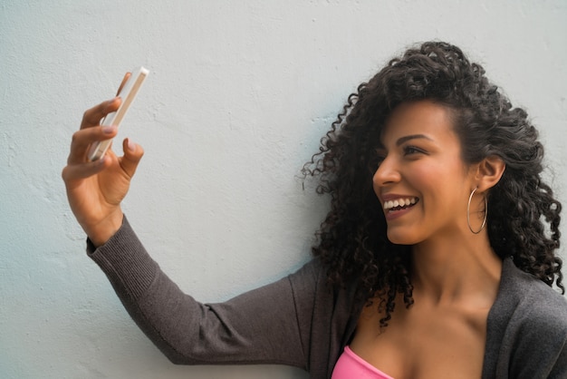 Donna di afro che prende i selfie con il telefono.