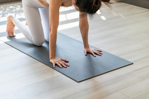 Donna di allenamento fitness in piedi alla lezione di yoga in piedi sulla stuoia di yoga in palestra