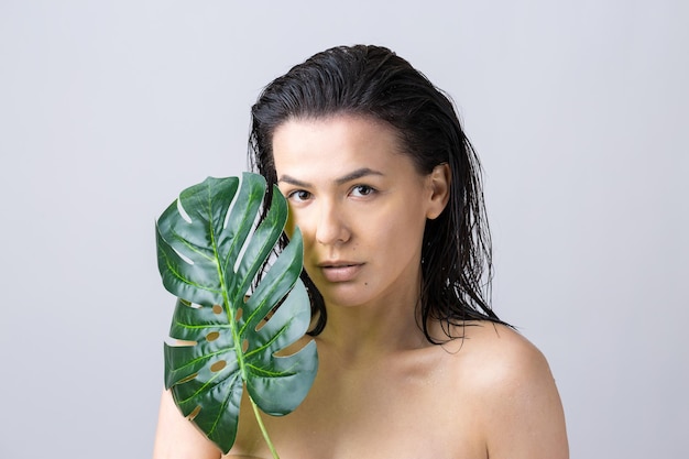 Donna di bellezza con ritratto di foglia di palma verde naturale Cosmetici per il trucco di bellezza alla moda