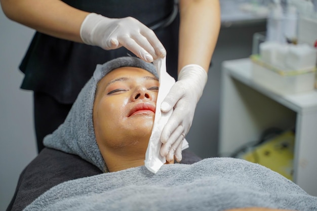 Donna di bellezza del primo piano che fa la stazione termale del viso e la maschera facciale