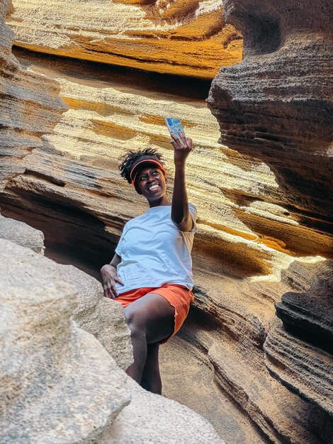 Donna di colore allegra che prende selfie nel canyon