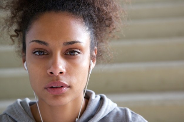 Donna di colore che ascolta la musica con gli auricolari