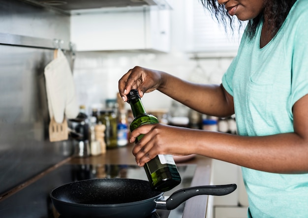 Donna di colore che cucina in cucina