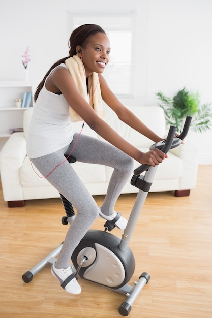 Donna di colore che fa la bici di esercitazione mentre sorridendo