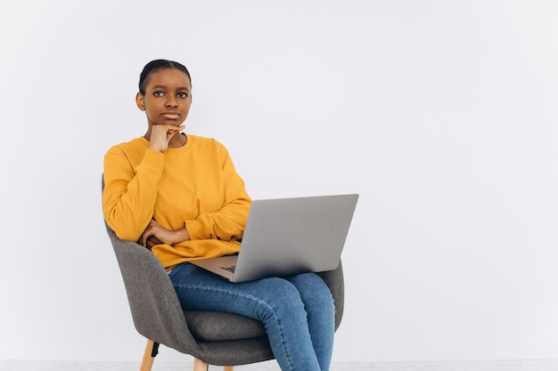 Donna di colore che lavora con il computer portatile a casa Giovane signora freelance afroamericana che usa il computer