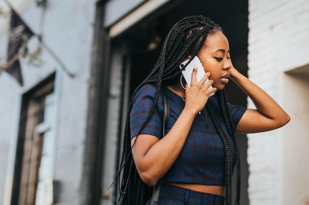 Donna di colore che parla al telefono mentre cammina per le strade