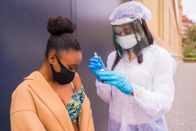 Donna di colore che riceve l'iniezione del vaccino contro il coronavirus da un medico