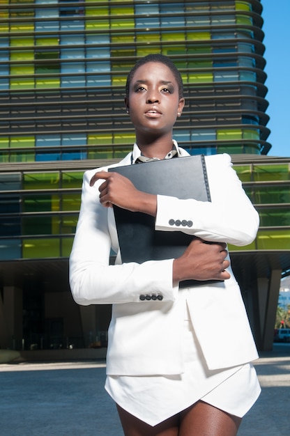 Donna di colore esecutiva nell'area degli affari in una città sotto un cielo blu