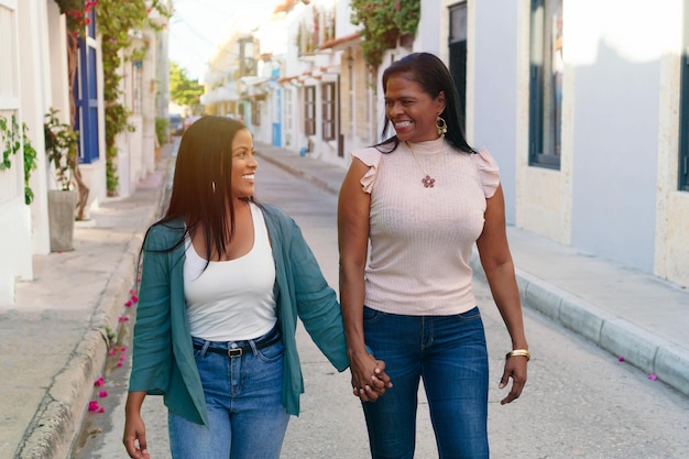 Donna di colore in strada che cammina con sua madre.