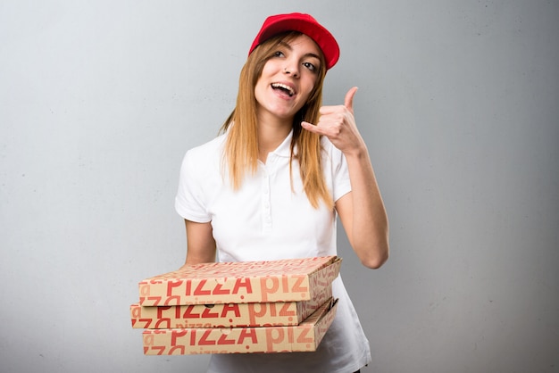 Donna di consegna della pizza che fa gesto del telefono su fondo strutturato