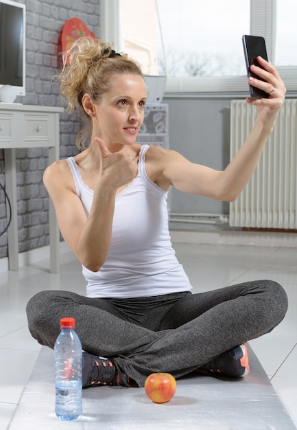 Donna di forma fisica che cattura foto con il suo telefono, dopo l'esercizio