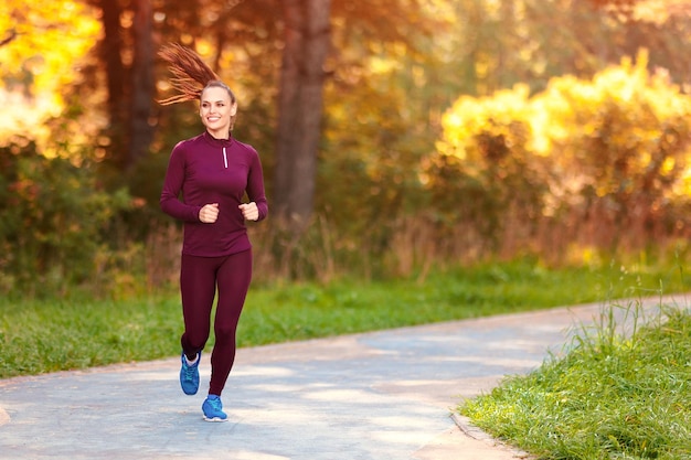 Donna di forma fisica che corre all&#39;aperto