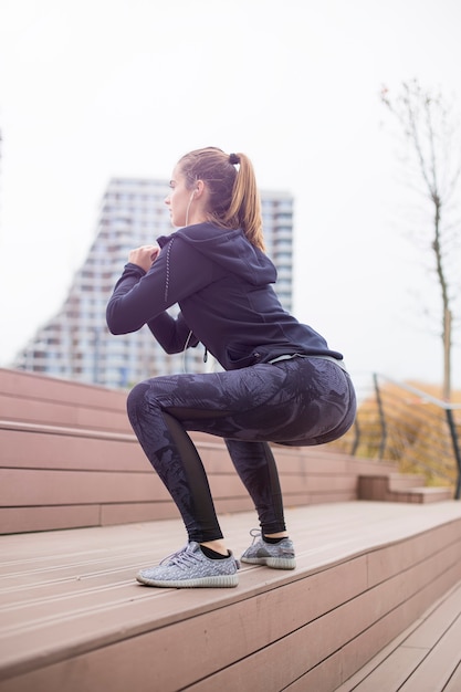 Donna di forma fisica che salta all&#39;aperto nell&#39;ambiente urbano