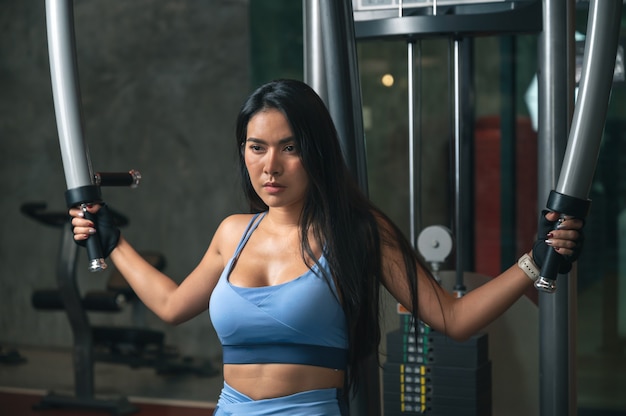 Donna di forma fisica con macchina di formazione in palestra