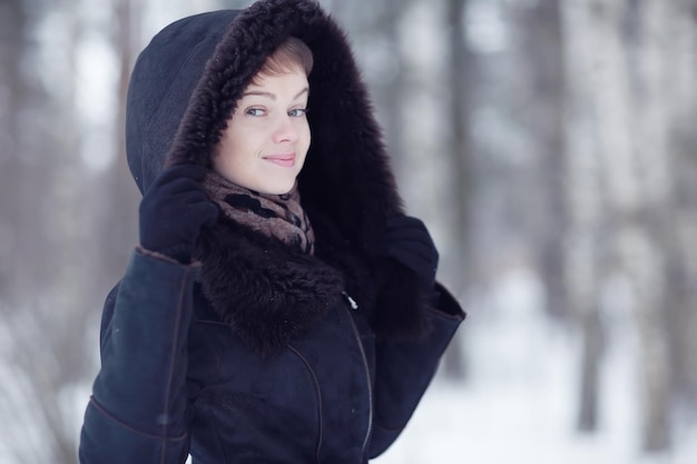 Donna di inverno in una pelliccia sulla neve fuori