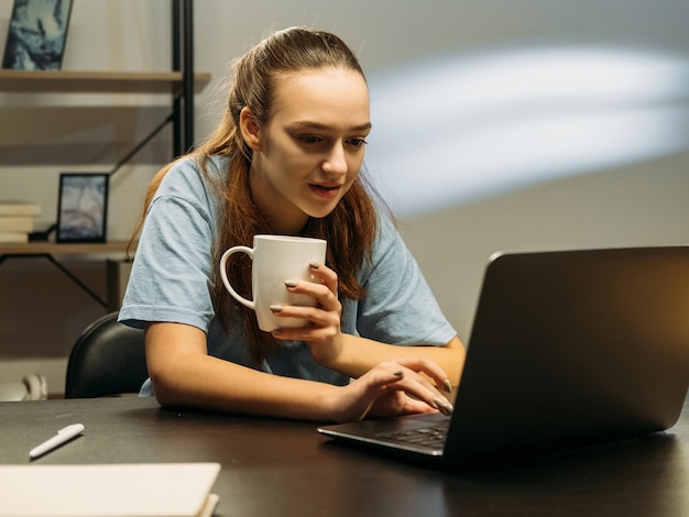 Donna di lavoro a distanza di lavoro notturno che utilizza il laptop