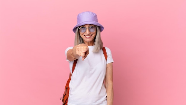 Donna di mezza età capelli bianchi che punta alla telecamera scegliendo te. concetto di estate