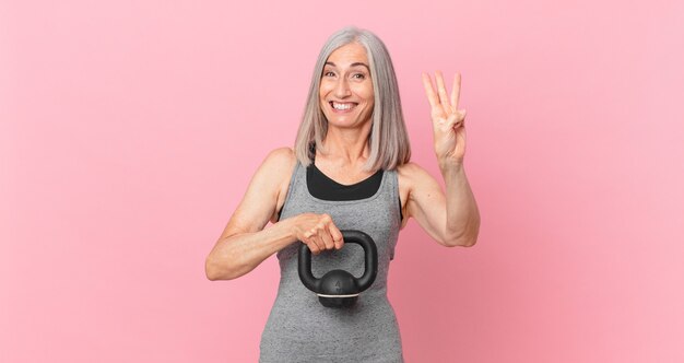 Donna di mezza età capelli bianchi che solleva un manubrio. concetto di fitness