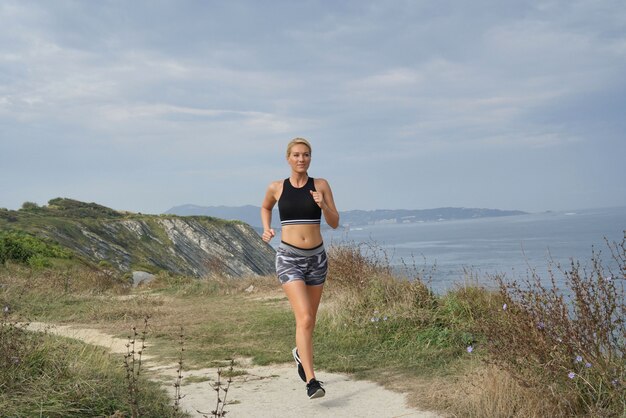 Donna di mezza età che corre fuori dal mare