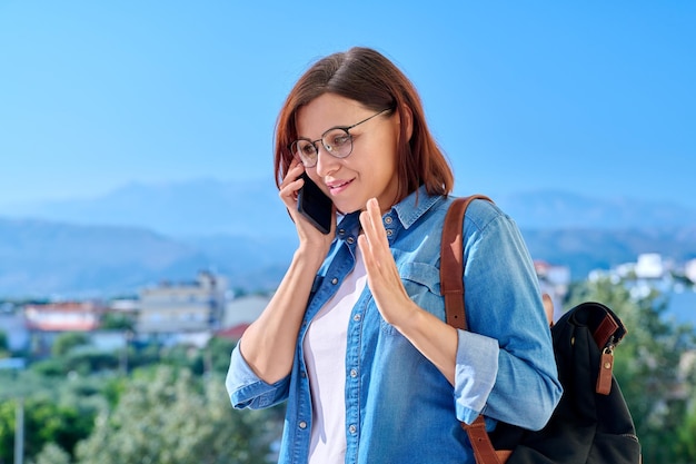 Donna di mezza età che parla al telefono all'aperto