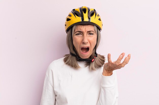 Donna di mezza età che sembra arrabbiata, infastidita e frustrata, concetto di casco da bici