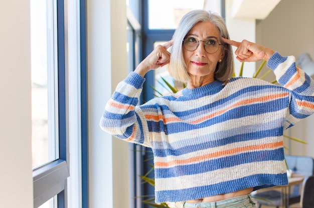 Donna di mezza età che si sente confusa o dubita, concentrandosi su un'idea, pensando intensamente, cercando di copiare lo spazio sul lato