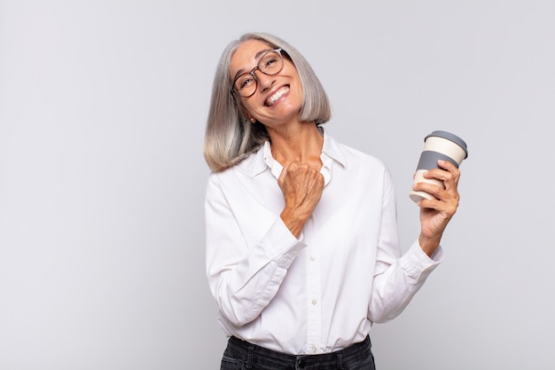 Donna di mezza età che si sente felice, positiva e di successo, motivata quando affronta una sfida o celebra i buoni risultati del concetto di caffè