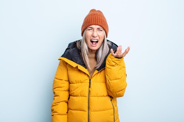 Donna di mezza età con capelli grigi che sembra arrabbiata, infastidita e frustrata, concetto di tempo freddo