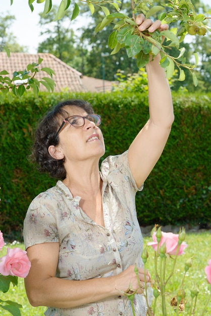 Donna di mezza età con gli occhiali in giardino