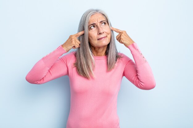 Donna di mezza età con i capelli grigi che sembra concentrata e pensa intensamente a un'idea, immaginando una soluzione a una sfida oa un problema