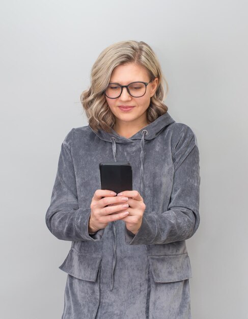 Donna di mezza età in occhiali messaggio di testo sullo smartphone