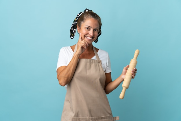 Donna di mezza età in uniforme del cuoco unico che pensa un'idea mentre osserva in su