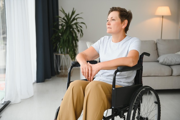 Donna di mezza età seduta su sedia a rotelle
