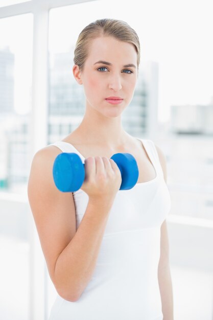 Donna di misura premurosa che si esercita con i dumbbells