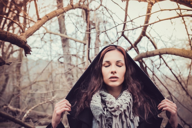 Donna di modo che cammina nel parco scuro di autunno