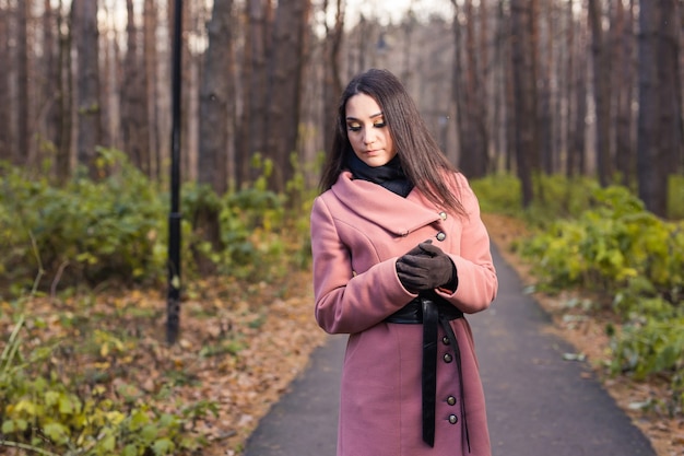 Donna di modo che cammina nella sosta di autunno