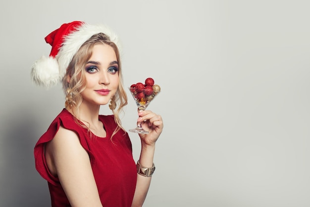 Donna di Natale con decorazione di Natale in bicchiere di vino su sfondo bianco