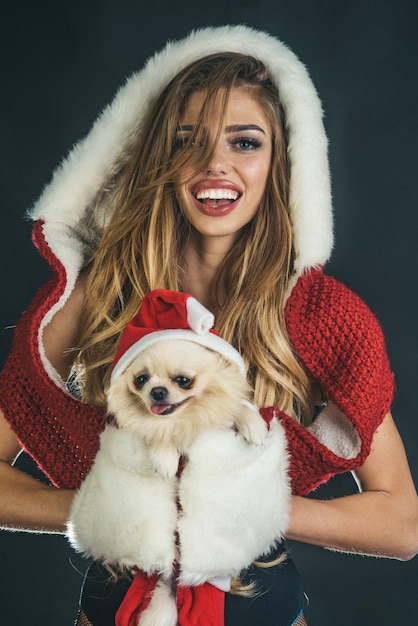 Donna di Natale con faccia felice e animale domestico. Nuovo anno di cane, cucciolo di attesa ragazza di Natale. Anno del cane, inverno, vacanza e Natale. Venerdì nero.