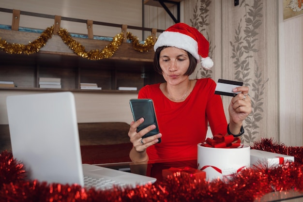 Donna di Natale sul computer portatile che fa shopping su Internet